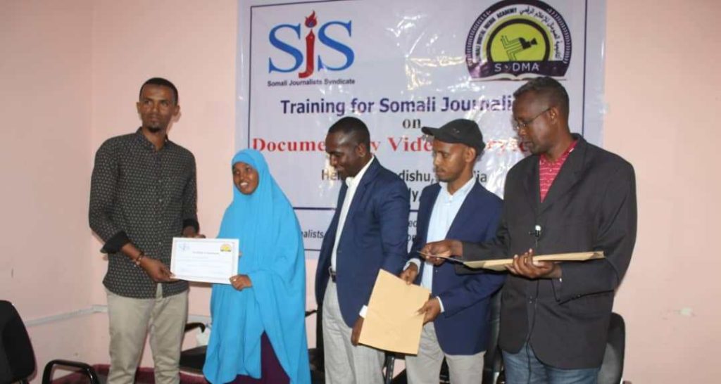 Trainer Abdukadir Zubeyr awards certificate to a female trainee during the conclusion of the two-week course on Documentary Video Storytelling in Mogadishu, on Thursday 8 August, 2019.