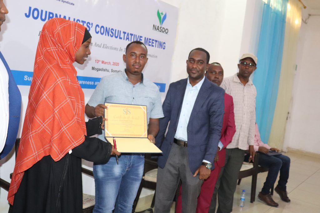 Nafisa Hersi Ogle (left), Secretary of Gender Rights of Somali Journalists Syndicate (SJS) hands certificate of award to journalist Abdiqani Abdullahi Ibrahim.