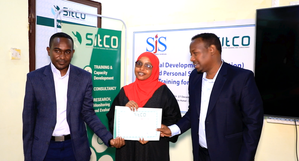 Hamdi Mahad Diriye (centre) journalist who covers social affairs for Radio Risaala receives certificate of completion at the end of three-day training on strategic planning in Mogadishu, Saturday 26 Dec, 2020. | PHOTO/SJS.