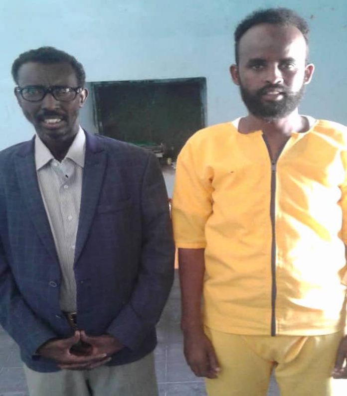 Freelance journalist Kilwe Adan Farah poses for a photo with his lawyer Mustafe Mohamed Jama during a trial at the military court in Garowe, on Saturday 27 Feb, 2021. | PHOTO/SJS.