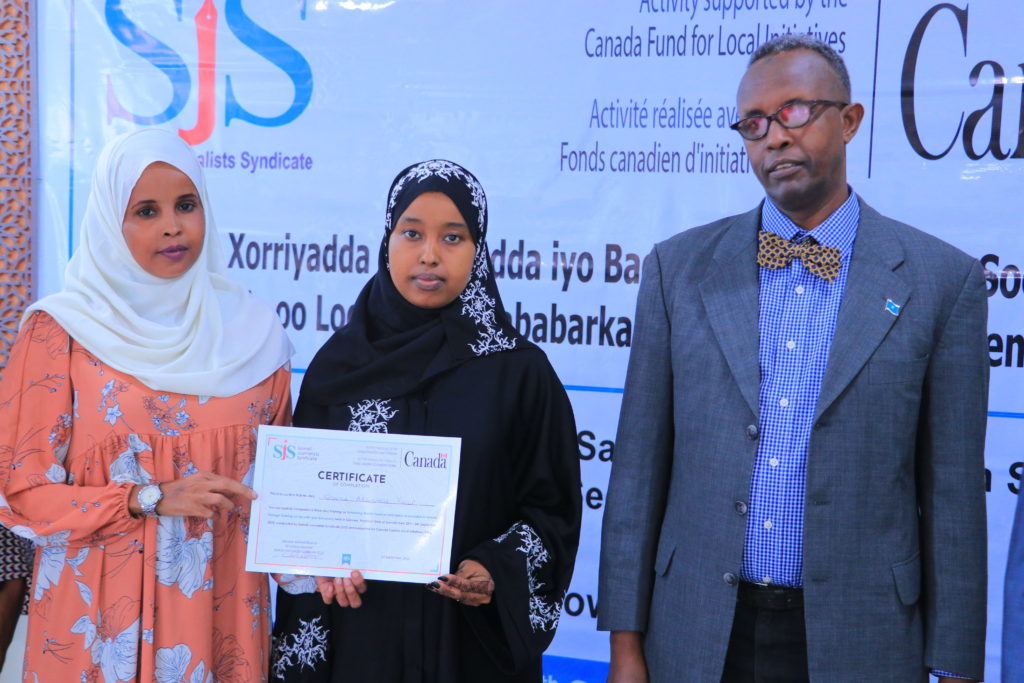 A female participant receives her certificate.